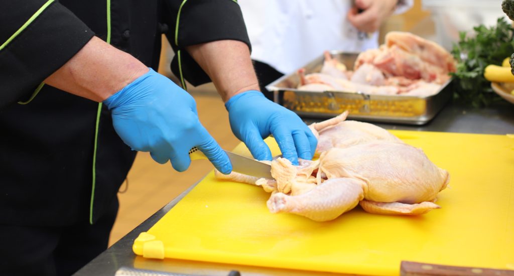 Phil butchering chicken during Epicurean Group Kitchen Class